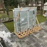 Verpackte Fenster auf einer Palette im Freien, bereit für die Montage von NORTA.