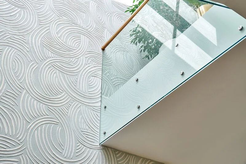 Modernes Glasgeländer mit Holzhandlauf von NORTA. Stilvolle Kombination aus Sicherheit und Design für Ihr Treppenhaus.