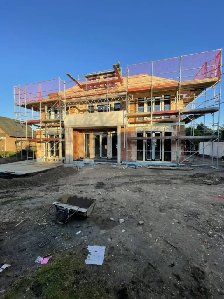 Neubau mit Gerüst und großen Glasfronten von NORTA. Moderne Architektur mit Aluminiumfenstern und Raffstoren in Köln.