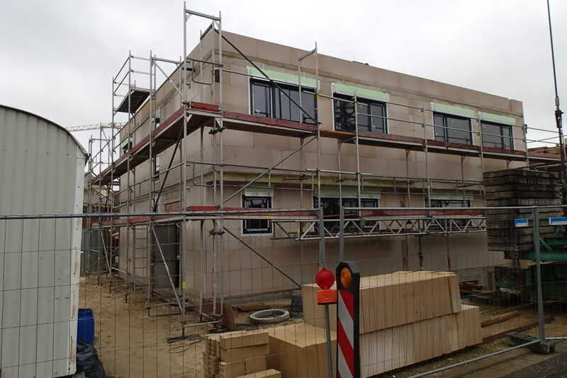 Einfamilienhaus im Bau mit Baugerüst und Schüco Fenstern. NORTA bietet hochwertige Baulösungen und moderne Fenstertechnik.