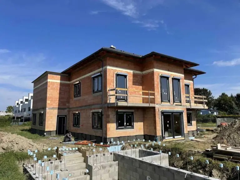 Einfamilienhaus im Rohbau mit großen Fenstern in ruhiger Lage. Moderne Bauweise von NORTA für energieeffizientes Wohnen.