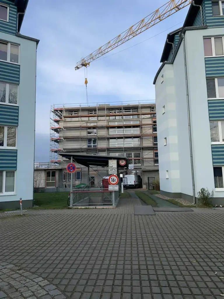 Gebäude mit Gerüst und Kran für Fassadenarbeiten von NORTA. Professionelle Bau- und Sanierungslösungen.