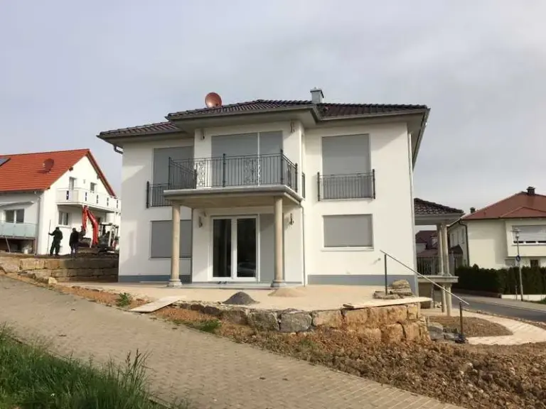 Modernes Haus mit NORTA Fenstern und Rollläden. Effiziente Beschattung und Energieeinsparung im stilvollen Design.