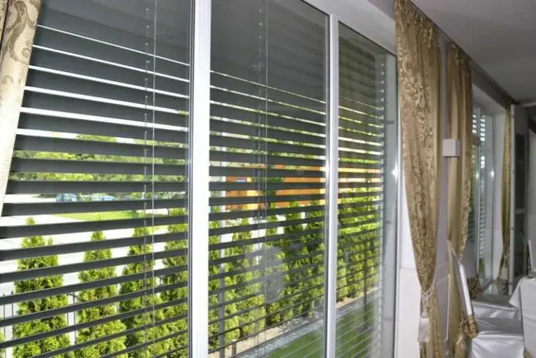 Moderne Raffstores mit Lamellen im Restaurant von NORTA. Effektiver Sonnenschutz und Stil für große Fensterfronten.