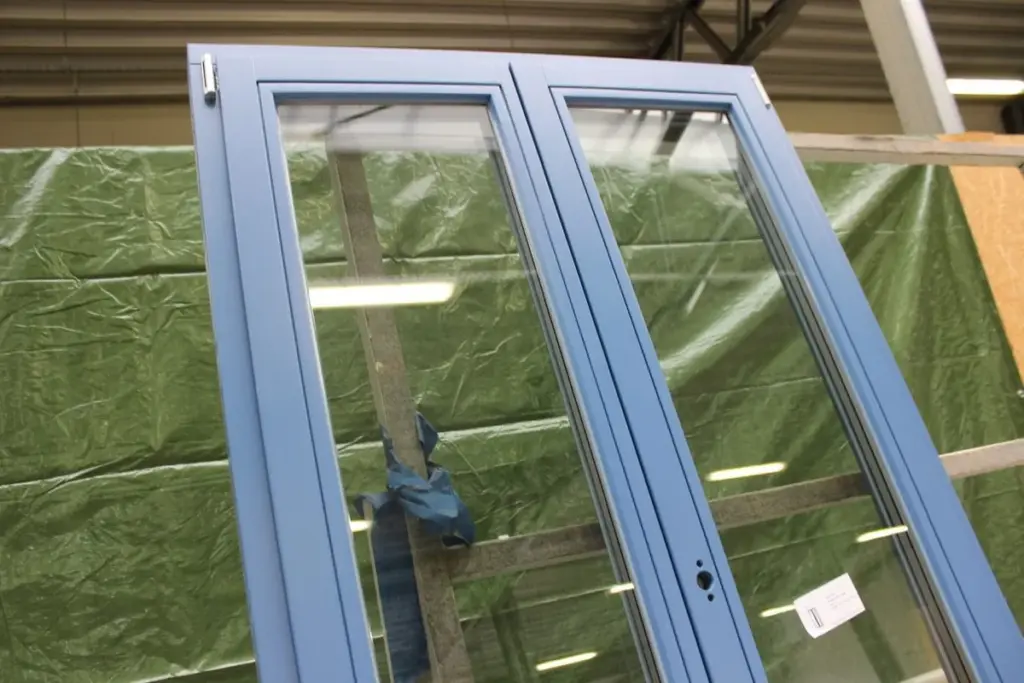 Hochwertiges blau lackiertes Holzfenster von NORTA mit Zweifachverglasung für optimale Wärmedämmung und ansprechendes Design.