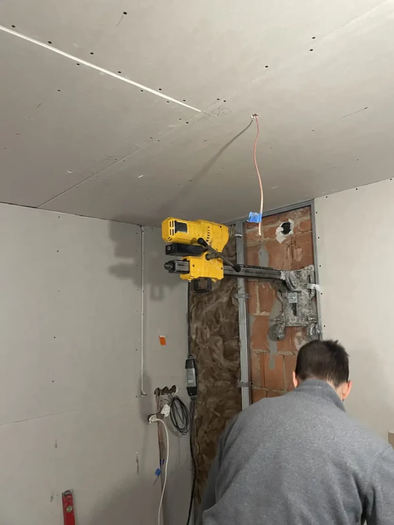 Blick durch eine perfekt runde Kernbohrung in einer Hochlochziegelwand, die die Struktur des Mauerwerks und das Tageslicht auf der anderen Seite zeigt.