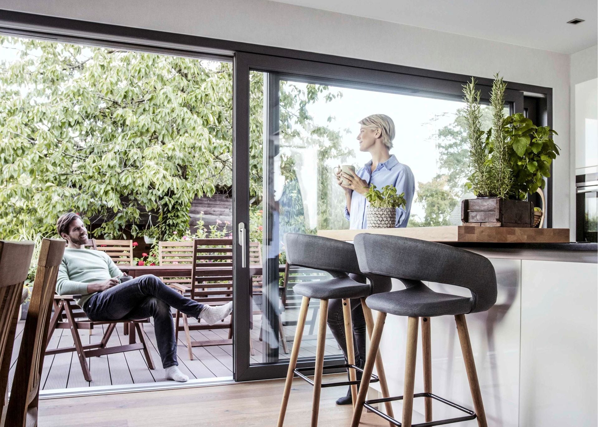 Geöffnete REHAU SYNEGO Hebeschiebetür zwischen Wohnküche und Terrasse