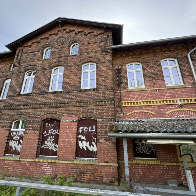 Altes Backsteingebäude mit neuen Holzfenstern von NORTA. Verbesserte Dämmung und stilvolle Optik für historische Bauten.