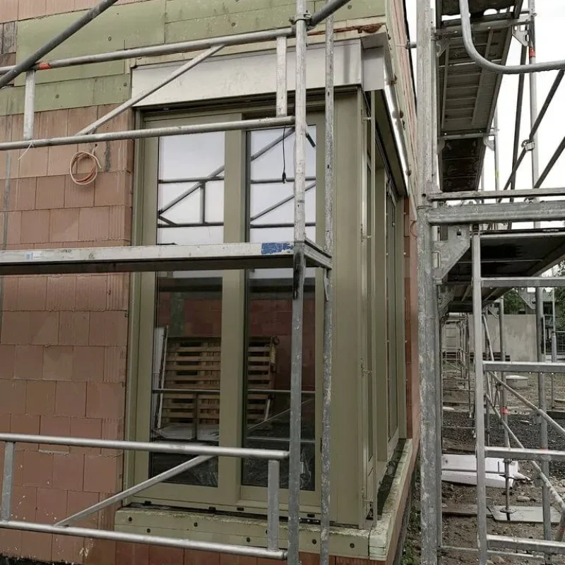 Alu-Fenster-Ecke mit Baustellenansicht in Grün von NORTA. Hochwertige Lösung für optimale Isolierung und moderne Architektur.