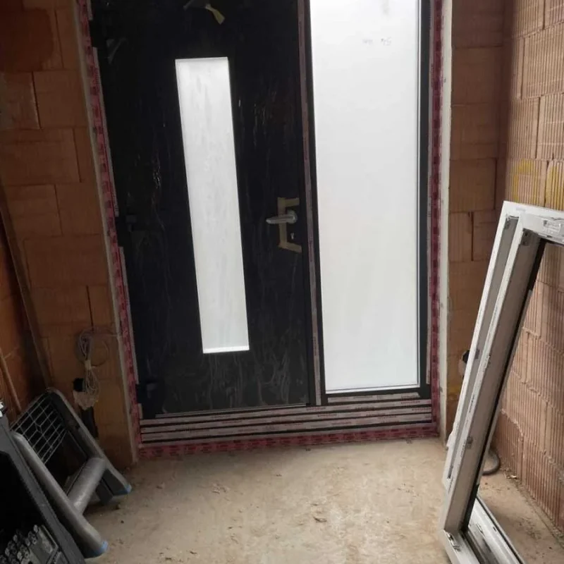 Moderne Aluminium-Haustür in Schwarz mit Seitenteil in Rohbau bei NORTA. Stilvoller Eingangsbereich in Entstehung.