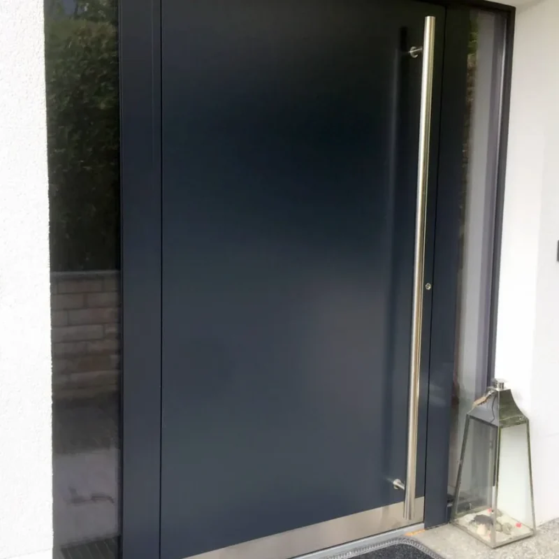 Moderne Aluminium-Haustür in Schwarzgrau von NORTA. Mit langem Edelstahlgriff für einen eleganten Eingangsbereich.