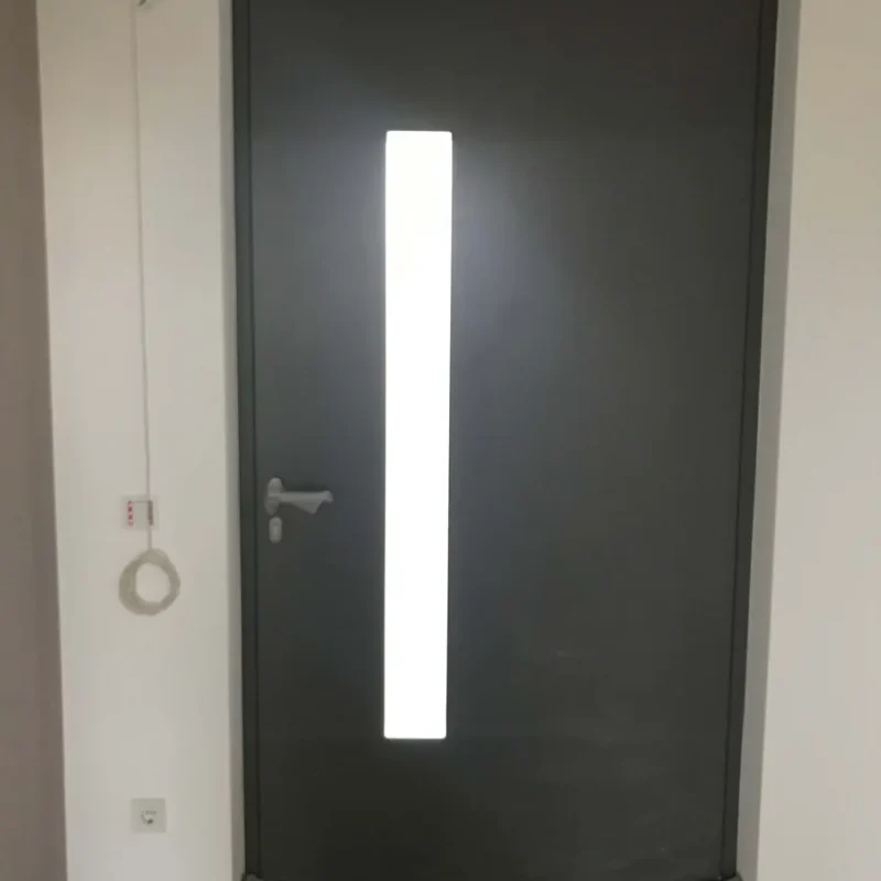 Moderne Aluminium-Haustür in Grau mit länglichem Sichtfenster von NORTA. Stilvoll und sicher für jeden Eingangsbereich.
