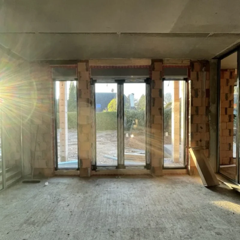 Rohbau mit großen Alu-Fenstern und Raffstoren von NORTA. Sonneneinstrahlung sorgt für helle Raumbeleuchtung.