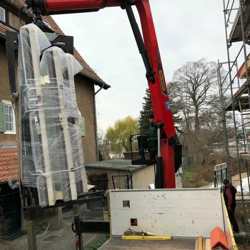 Montage von NORTA Alufenstern und Glasgeländern mit Kran. Sichere Lieferung und Installation für moderne Gebäude.