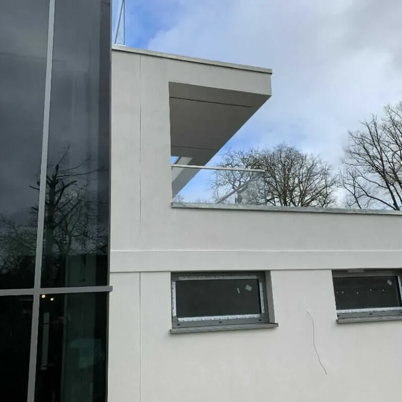 Modernes Gebäude mit großen NORTA Alufenstern und Glasgeländern, bietet stilvolle Transparenz und Langlebigkeit.
