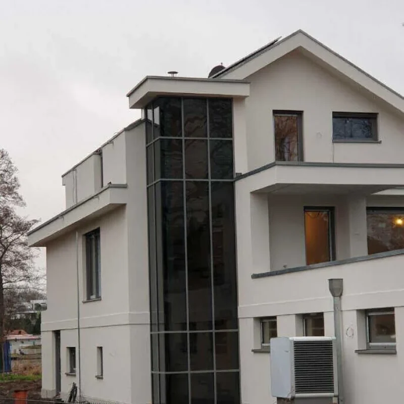 Modernes Gebäude mit Aluminiumfenstern und Glasgeländer von NORTA. Stilvolle Fassade für exklusives Wohnen.