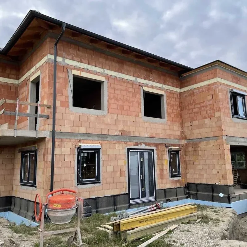 Rohbau eines Einfamilienhauses mit sichtbaren Ziegelmauern. Optimale Vorbereitung für Fensterinstallation durch NORTA.