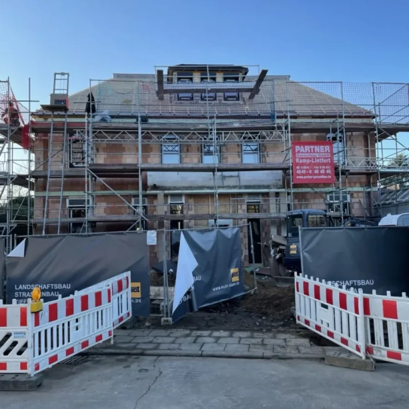 Haus in Renovierung mit Gerüst und Absperrungen. Perfekte Vorbereitung für Fenster- und Raffstore-Installation von NORTA.