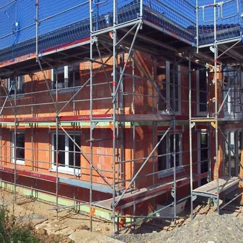 Bau eines Hauses mit Fenstern und Rollläden von NORTA in Kitzingen. Vormontagestadium mit Gerüst für effiziente Installationen.