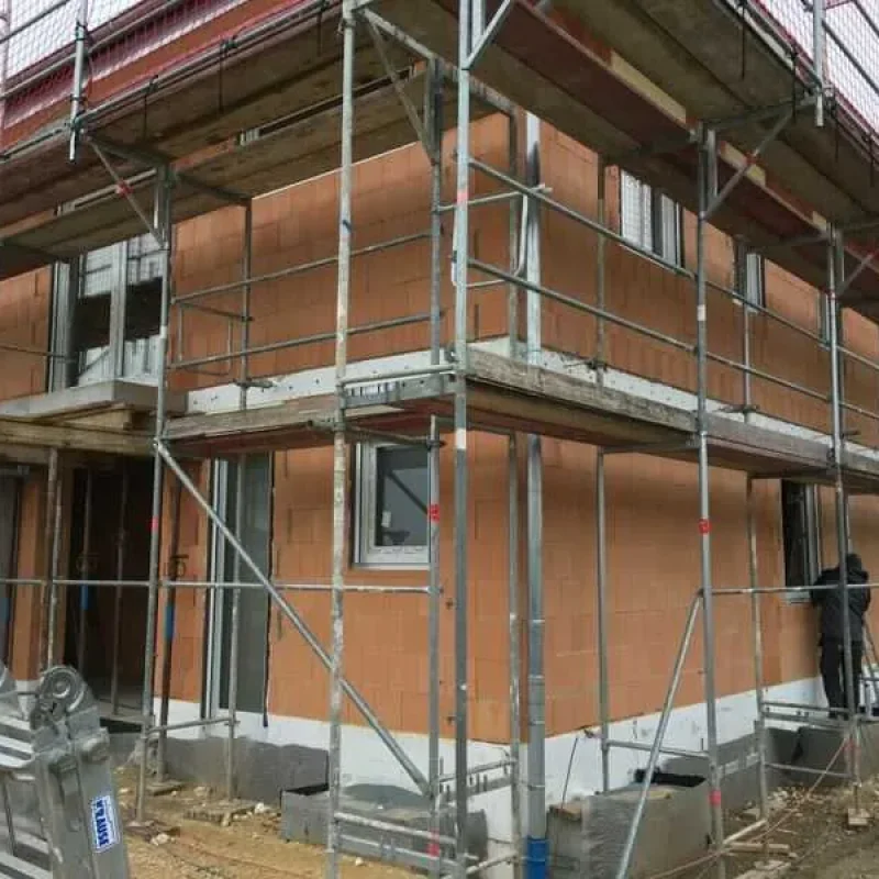 Im Bau befindliches Gebäude mit Gerüst und Fenstereinbau von NORTA. Hochwertige Fensterlösungen für modernes Wohnen.