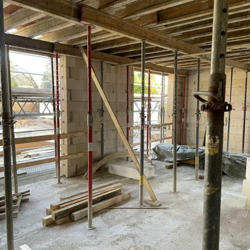 Rohbau eines Doppelhauses in Köln. Stabile Konstruktion mit Unterstützungsträgern und Sichtschutz, bereit für Fenster von NORTA.