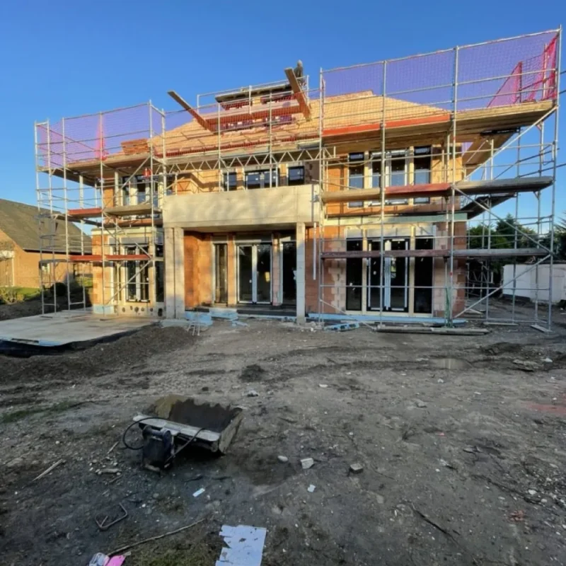 Neubau mit Gerüst und großen Glasfronten von NORTA. Moderne Architektur mit Aluminiumfenstern und Raffstoren in Köln.