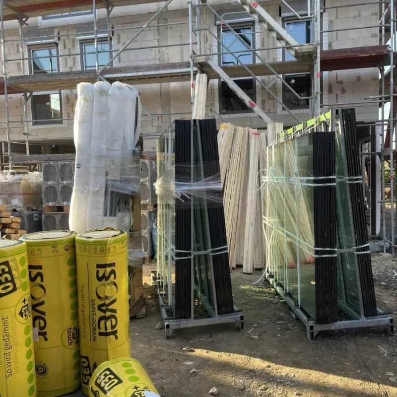 Baustelle eines Doppelhauses mit Glas und Isolierung von NORTA. Moderne Materialien für Energieeffizienz und Dämmung.