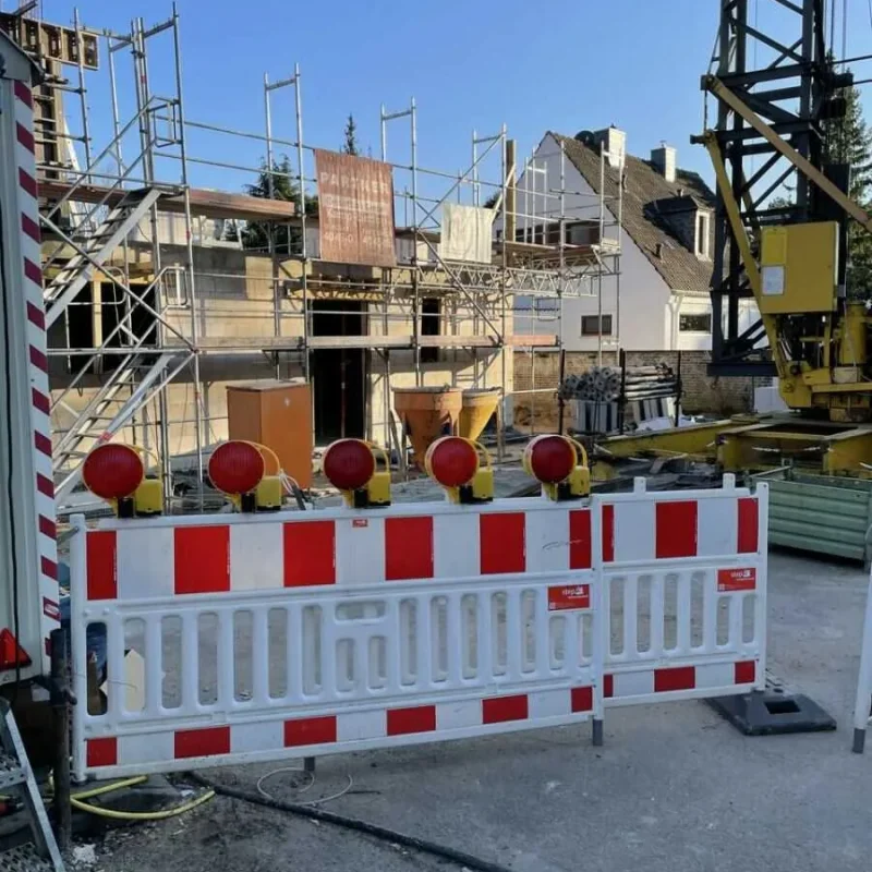 Baustelle eines Doppelhauses in Köln. Gerüste und Baukran sichtbar. Bauprojekt für moderne Häuser von NORTA.