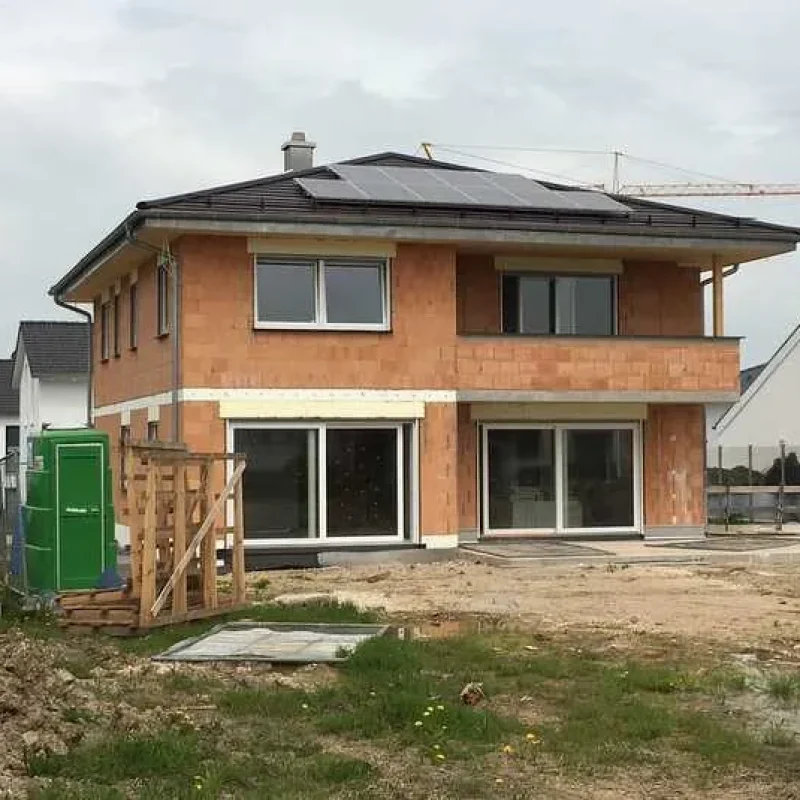 Baustelle eines Einfamilienhauses mit NORTA Fenstern. Moderner Neubau mit großen Fensterelementen und Photovoltaikanlage.