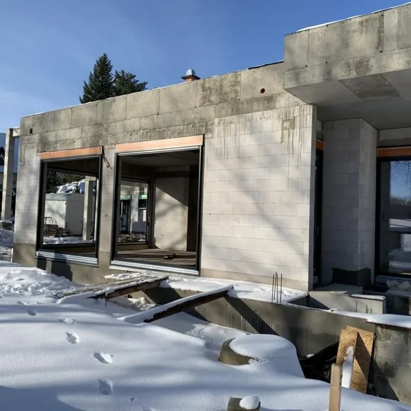 Baustelle mit Aluminium-Fenstern von NORTA im Winter, schneebedeckt. Qualität und moderne Optik für Neubauten.