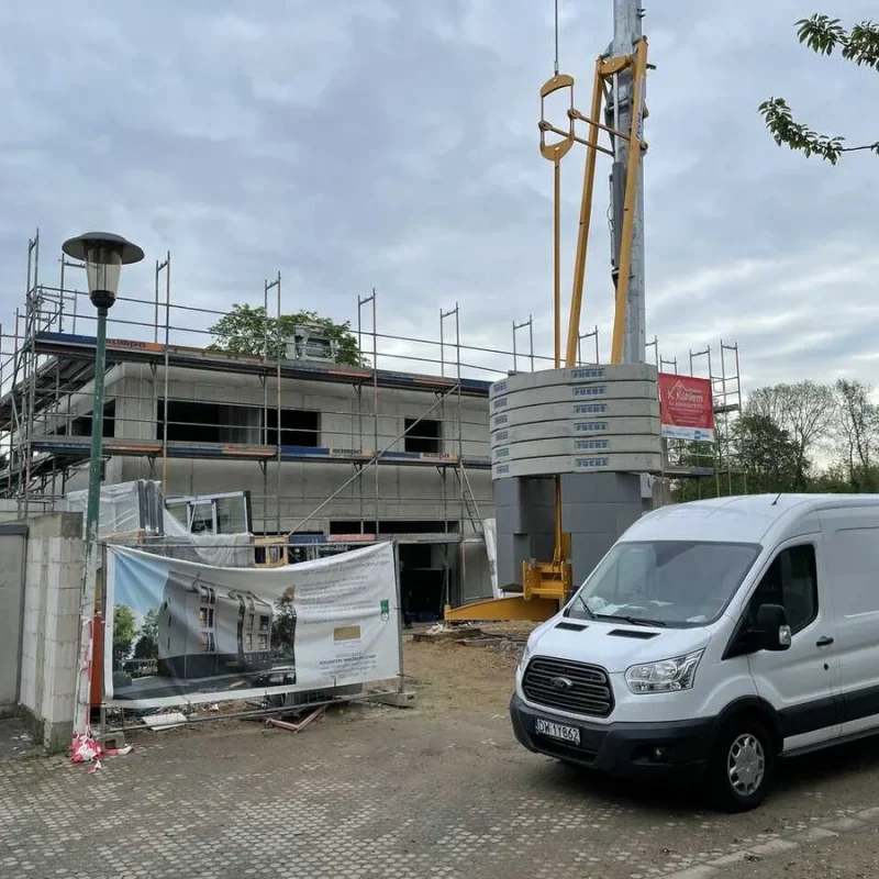 Baustelle einer neuen Einrichtung in Köln. Fortschritt des Bauvorhabens mit Rohbau und Baugerät. Moderne Architektur in Planung.
