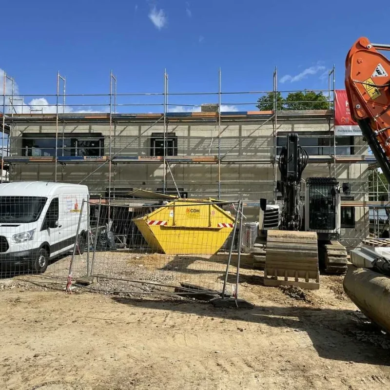 Baustelle eines Kindergartens in Köln mit Baugerüst und Baufahrzeugen. Fortschritt bei der Kindergartenerneuerung.