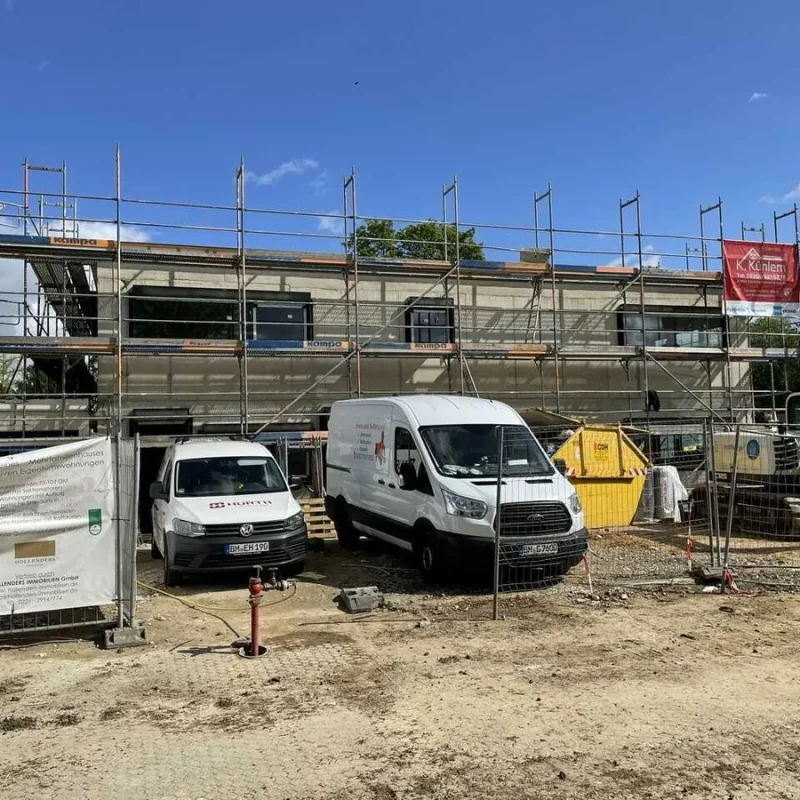Baustelle eines Kindergartens in Köln. Gebäude im Bau mit Gerüst und Fahrzeugen im Vordergrund. NORTA Fensterlösungen möglich.