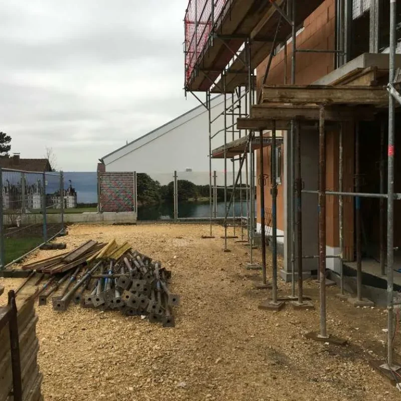 Baustelle mit Gerüst im Hausbau, zeigt die Fortschritte der Konstruktion. Optimale Voraussetzungen für zukünftige NORTA Produkte.