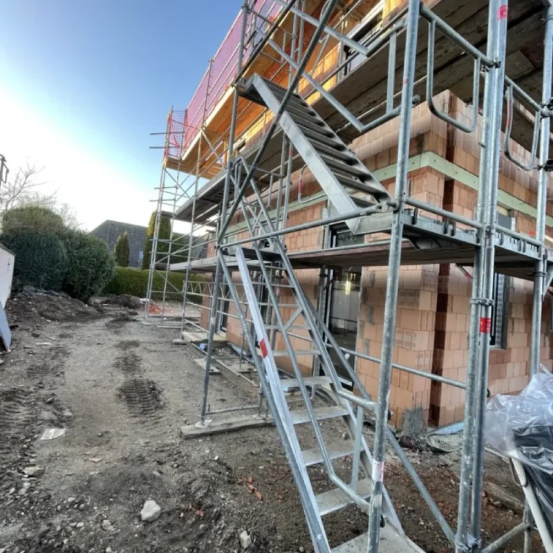 Baustelle mit Gerüst und Rohbau eines Gebäudes. Vorbereitung für Fensterinstallation durch NORTA für optimale Lösungen.