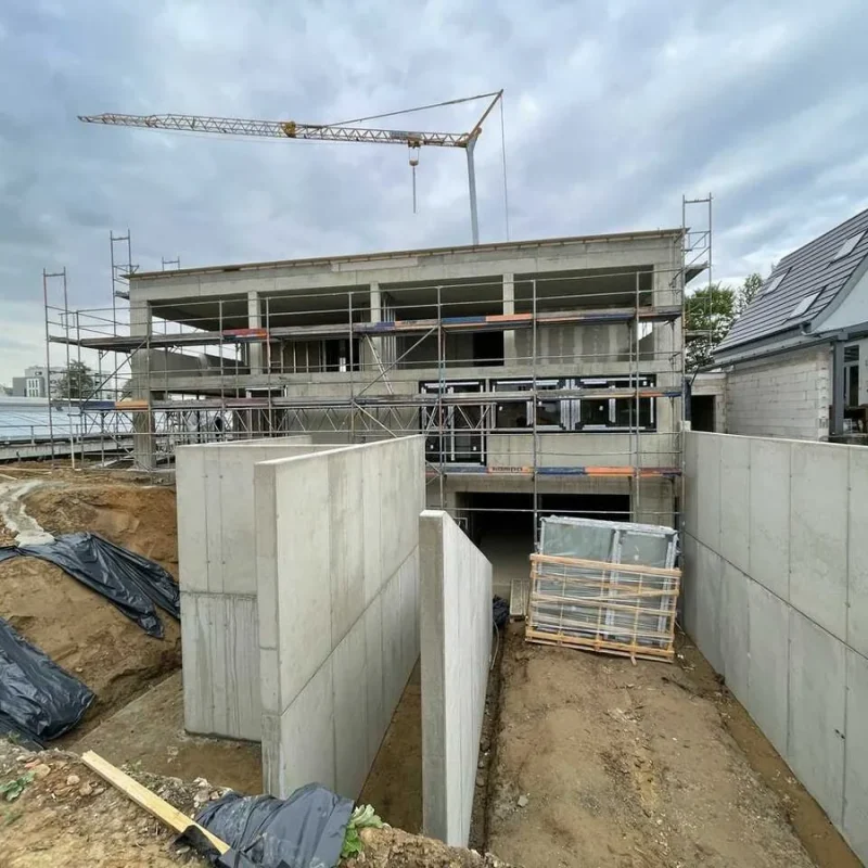 Baustelle eines neuen Kindergartens in Köln. Das Gebäude ist im Rohbau, mit Baugerüst und Baukran. NORTA Projektentwicklung.