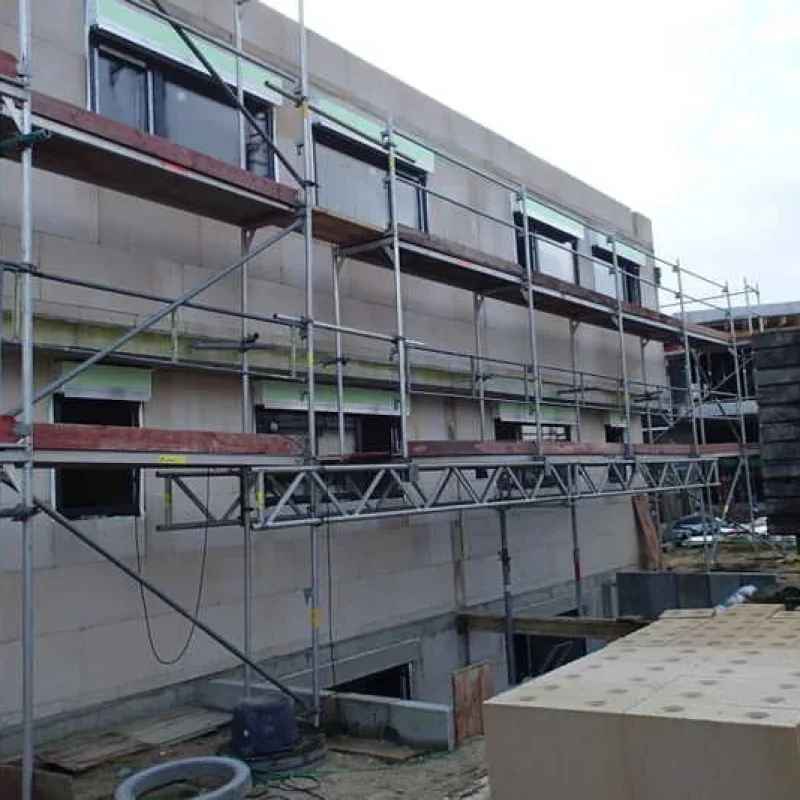 Einfamilienhaus mit Baugerüst, Raffstoren und Schüco Fenstern von NORTA in der Montagephase. Effiziente Bauweise für maximale Energieeinsparung.