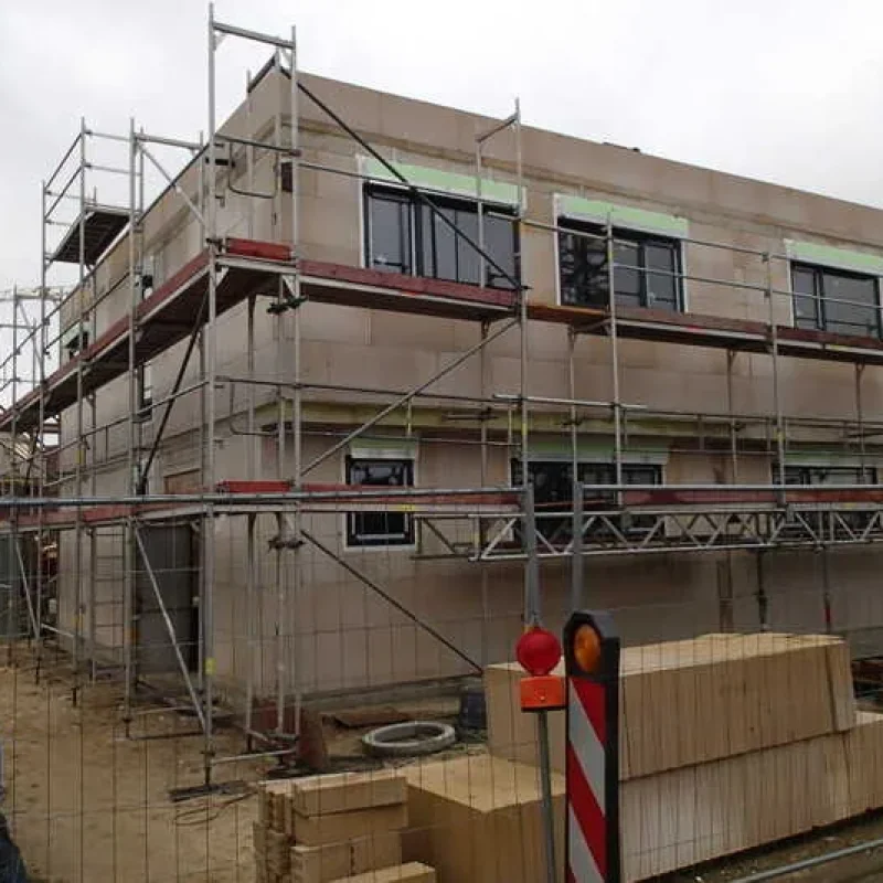 Einfamilienhaus im Bau mit Gerüst und Schüco Fenstern. Bauqualität von NORTA für moderne Wohnprojekte.