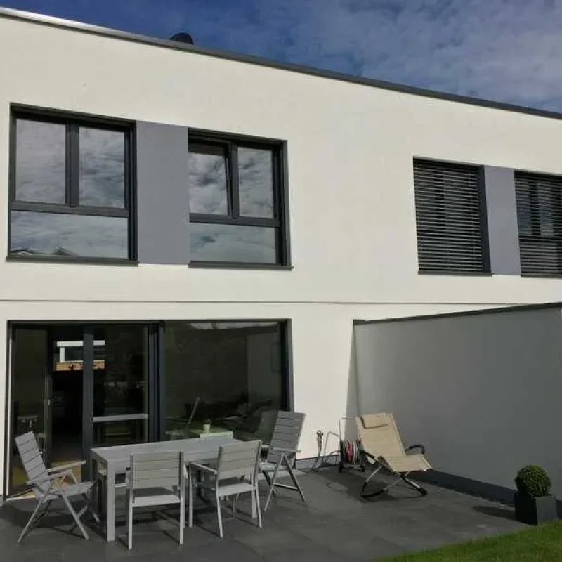 Modernes Einfamilienhaus mit Schüco Fenstern und Raffstoren von NORTA. Hohe Energieeffizienz und stilvolle Gestaltung.