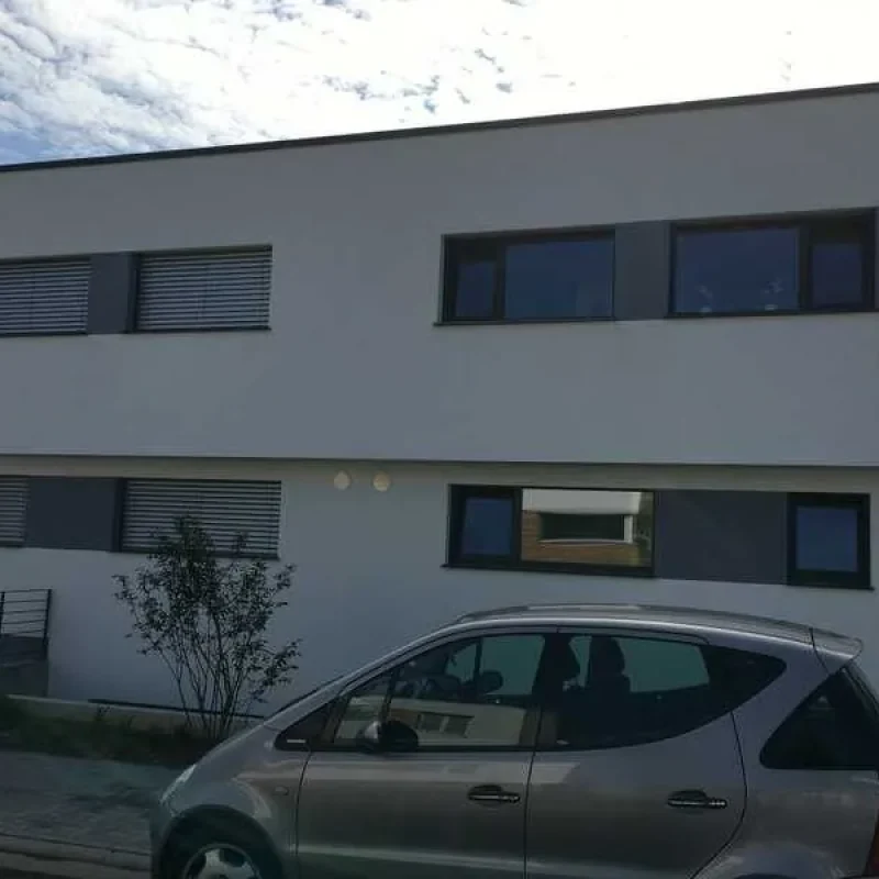 Modernes Einfamilienhaus mit Schüco Fenstern und Raffstoren im Aufsatzkasten von NORTA. Stilvolle und funktionale Architektur.