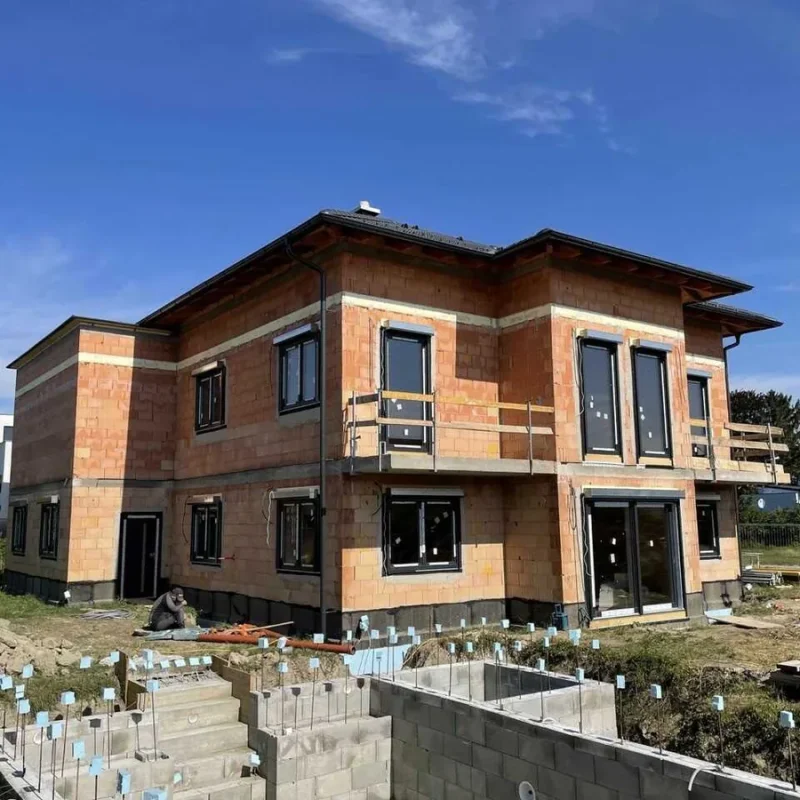 Einfamilienhaus im Rohbau mit großen Fenstern in ruhiger Lage. Moderne Bauweise von NORTA für energieeffizientes Wohnen.