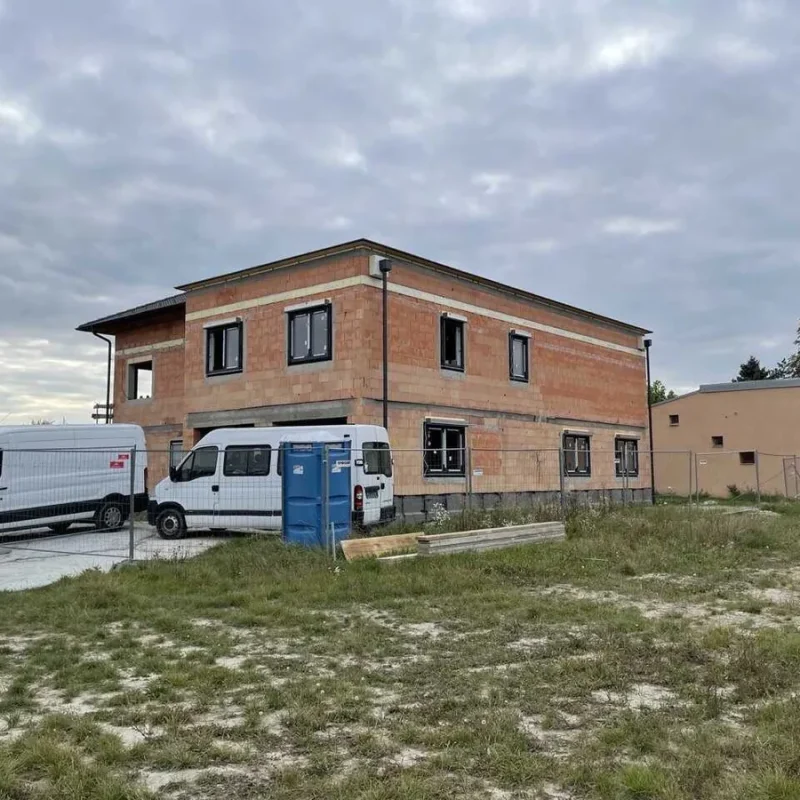 Rohbau eines Einfamilienhauses in Wien. Moderne Baustelle mit zwei Transportern neben dem Gebäude für NORTA.