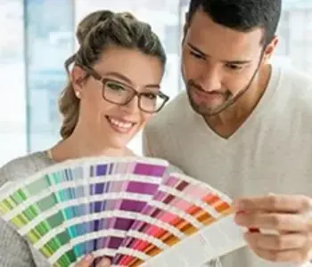 Zwei Personen betrachten eine Farbpalette. Beratung zur Farbauswahl für Fenster und Türen bei NORTA.