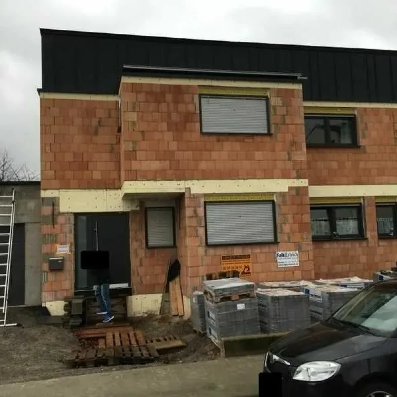 Fassade eines Rohbaus mit heruntergelassenen Rollläden von NORTA. Schutz und Privatsphäre für moderne Bauprojekte.