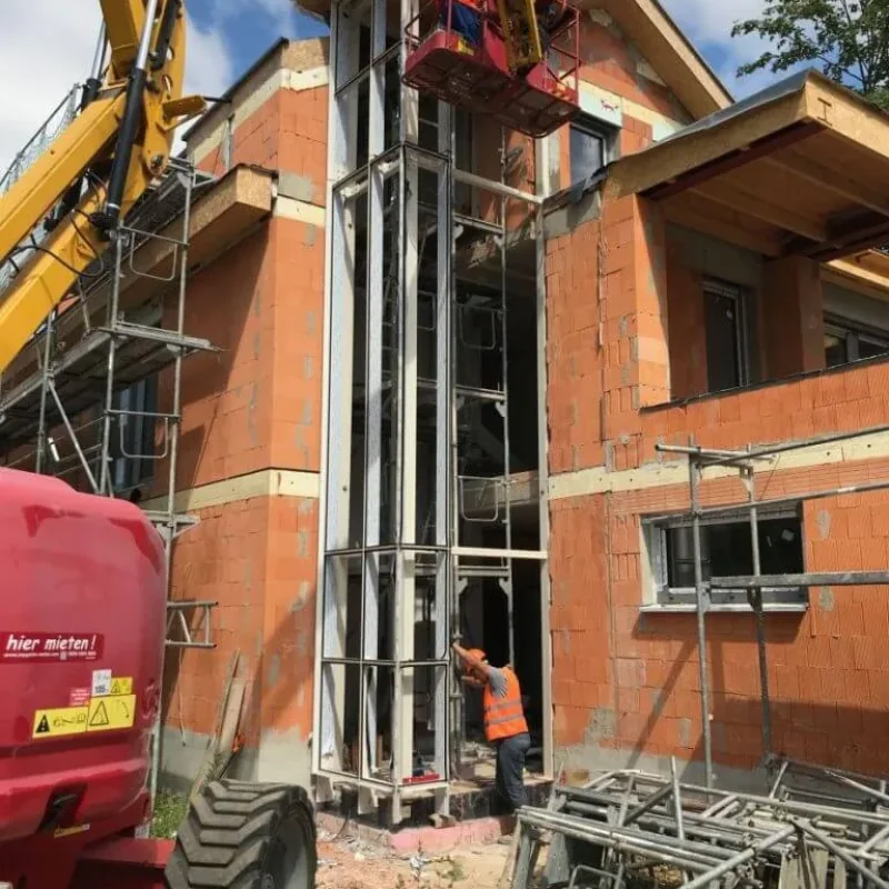Baustelle in Potsdam mit Fassadenkonstruktion von NORTA. Arbeiter installieren moderne Fassadenelemente für optimale Dämmung.