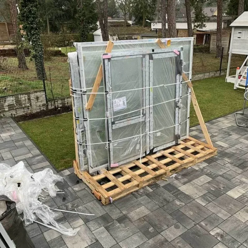 Fenster mit Alukonstruktion und Raffstore von NORTA, sorgfältig verpackt auf einer Palette zur Auslieferung vorbereitet.