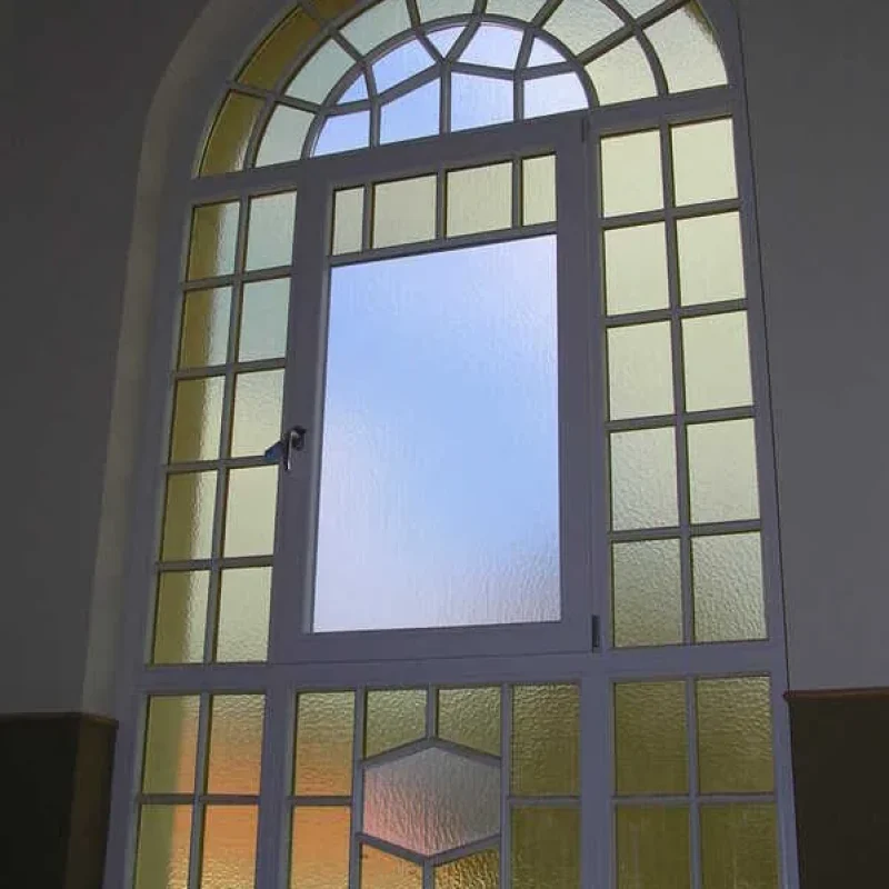 Bogenförmiges Fenster mit dekorativer Verglasung von NORTA. Ideal für stilvolle Lichtdurchflutung und Ästhetik im Innenbereich.