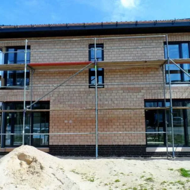 Moderne Schüco Fenster in Anthrazit von NORTA in einem Neubau mit Gerüst. Hochwertige Lösung für Energieeffizienz und Design.