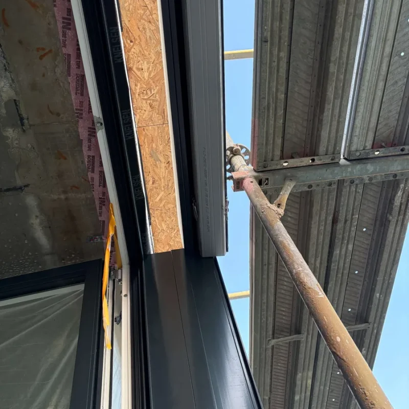 Einbau eines schwarzen Fensters von NORTA. Hochwertige Lösung für optimale Isolierung und modernes Design im Wohnbau.