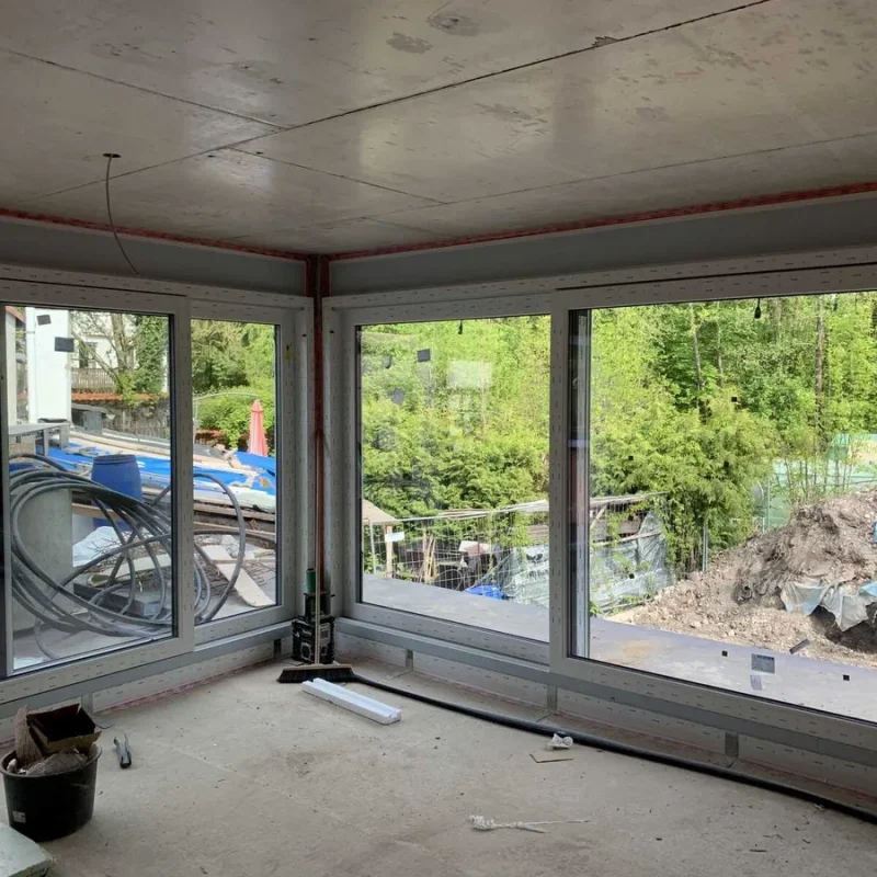 Große Fensterfront während des Einbaus in einem modernen Wohnraum von NORTA. Bietet maximalen Tageslichteinfall und Ausblick.